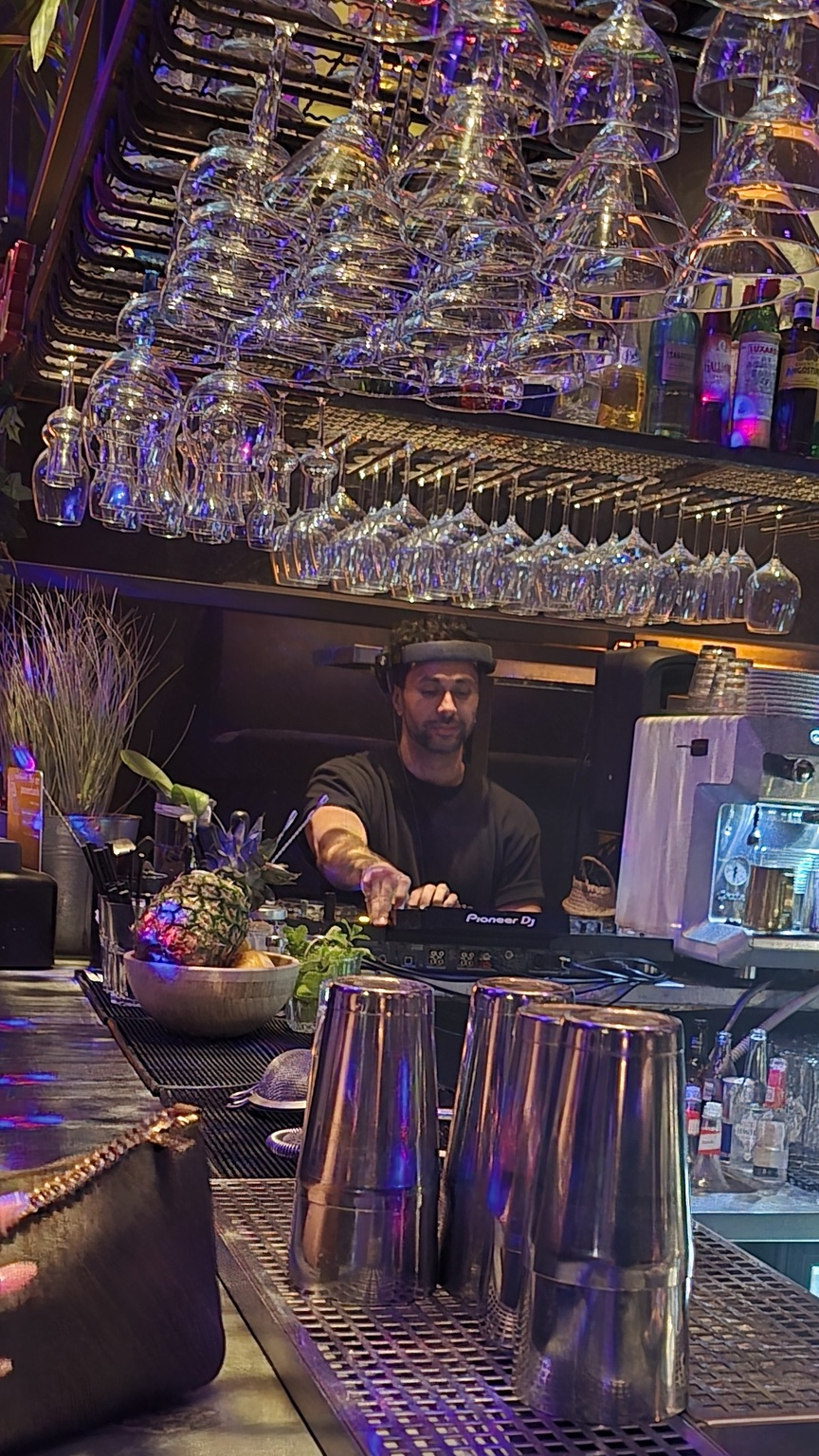 Merano spelar bakom baren under färgade ljus