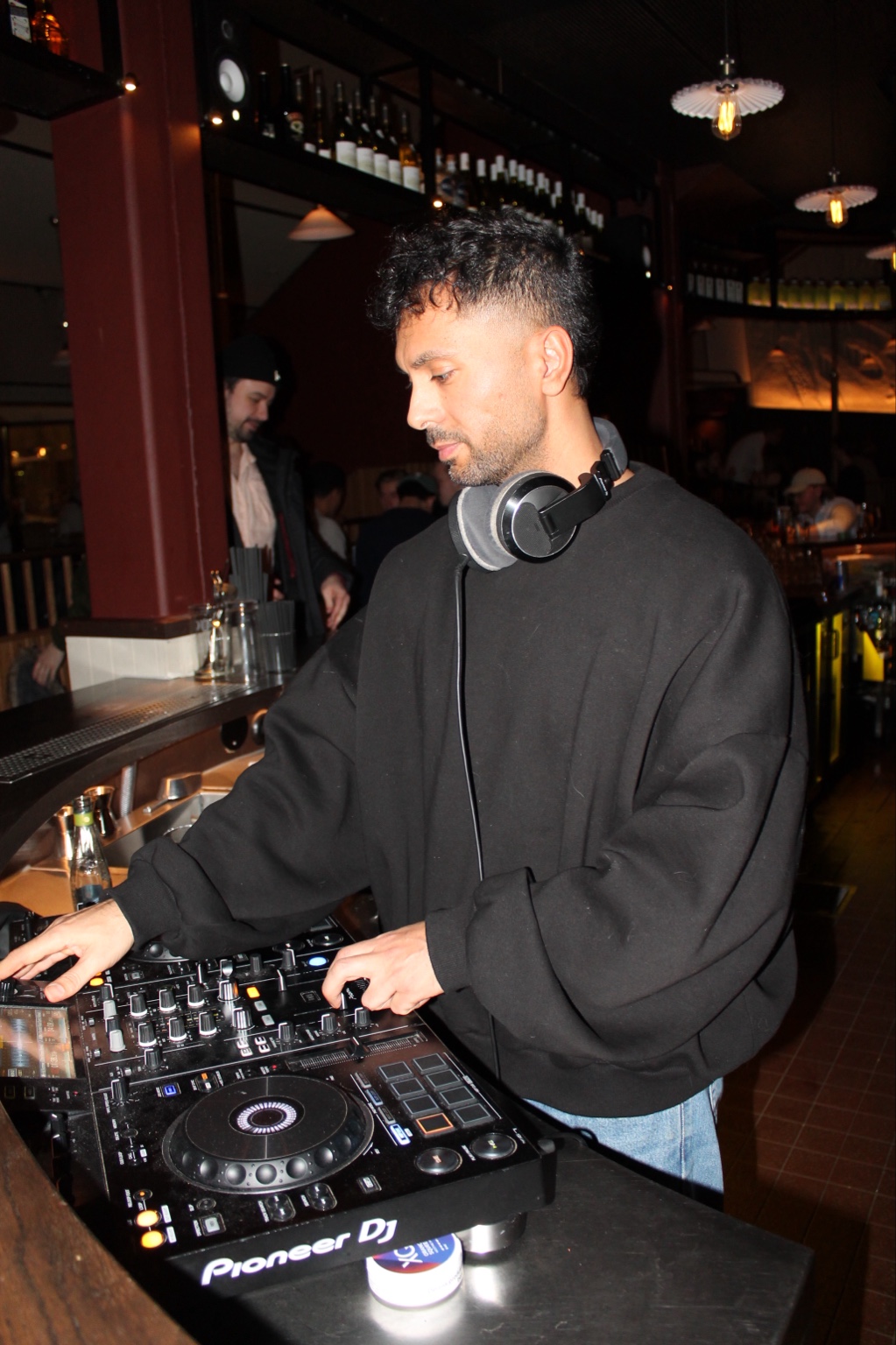 Merano arbetar vid DJ-mixern i en bar