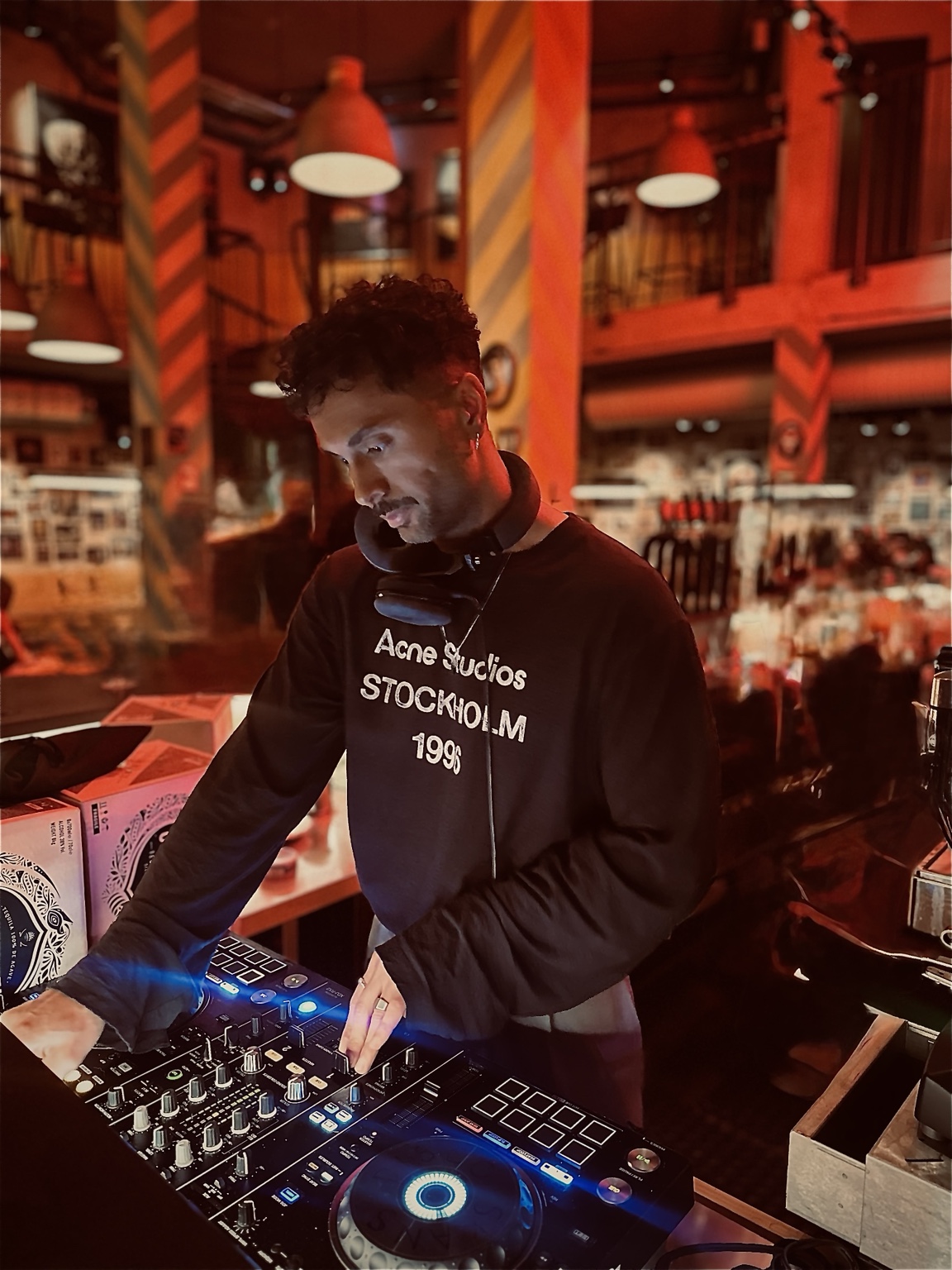Merano bakom DJ-båset i varmt rött ljus